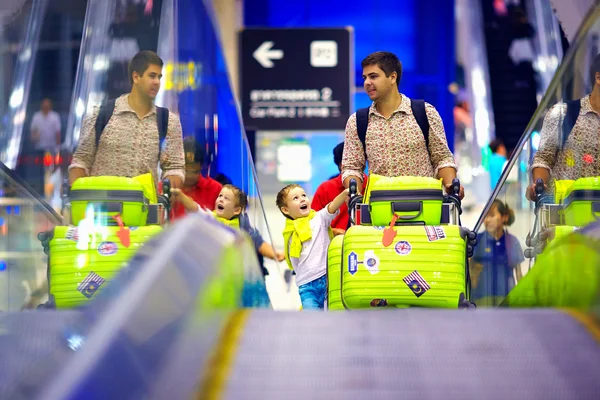 Famille heureuse avec bagages sur convoyeur à l'aéroport, prêt à voyager — Photo