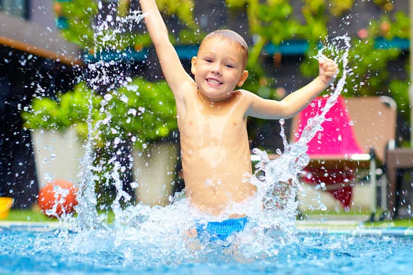 Opgewonden gelukkig kind jongen springen in het zwembad, waterplezier — Stockfoto