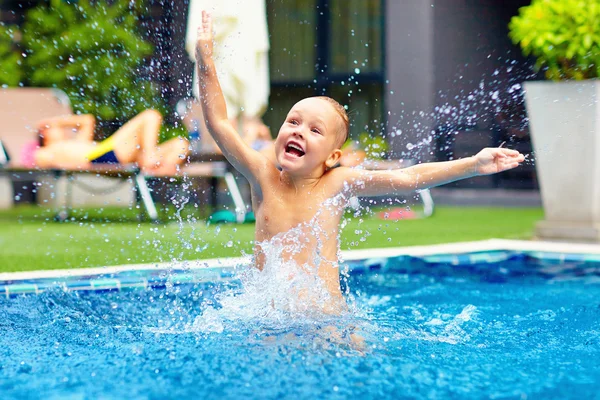 Opgewonden gelukkig kind jongen springen in het zwembad, waterplezier — Stockfoto