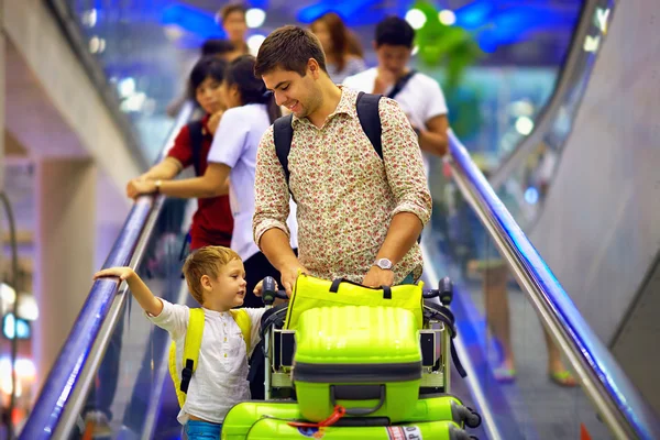 Glückliche Familie mit Gepäck auf dem Band im Flughafen, bereit zur Reise — Stockfoto