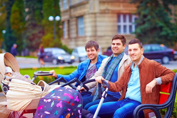 Trois pères heureux sur la promenade de la ville dans le parc — Photo