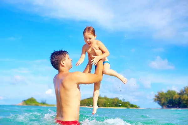 Alegre padre e hijo divirtiéndose en el agua en la playa tropical —  Fotos de Stock