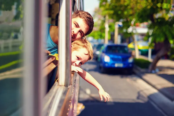 Padre e hijo viajando en autobús público sin ventanas, a través de — Foto de Stock