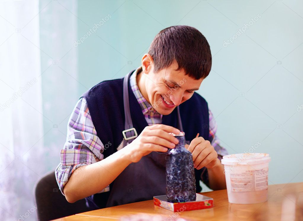 young adult man with disability engaged in craftsmanship on prac