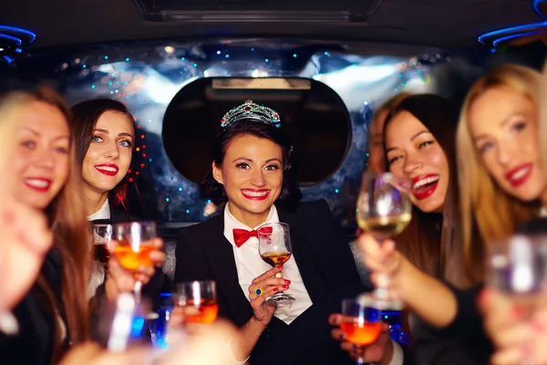 Група щасливих елегантних жінок смердить окуляри в лімузині, вечірка з куркою — стокове фото