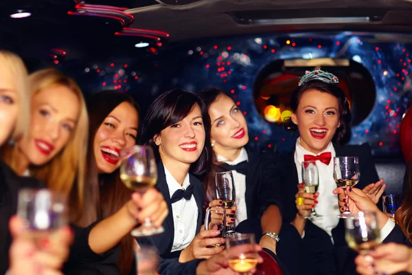 Groupe de femmes élégantes heureux cliquetis lunettes en limousine, fête de poule — Photo
