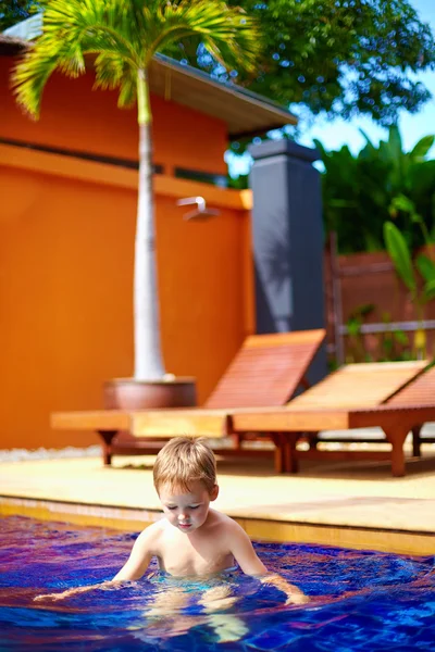 Garoto bonito, menino nadando na piscina do hotel — Fotografia de Stock