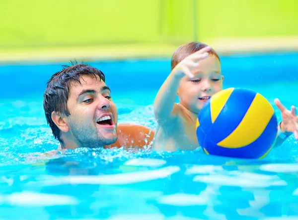 Happy family playing in water polo in the pool — Stock Photo, Image