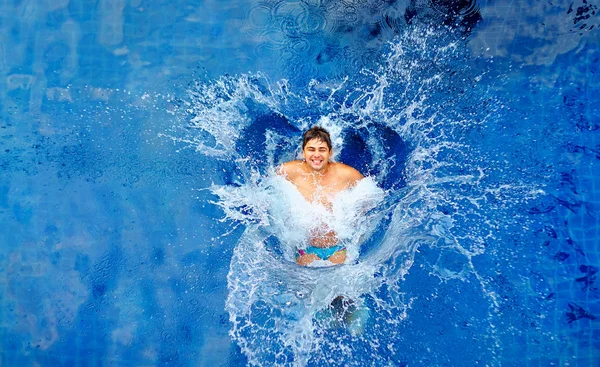 Homem pulando na piscina, enorme respingo, vista superior — Fotografia de Stock