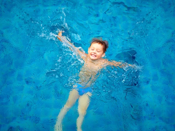 Cute kid, boy swimming in pool water, top view — Stock Photo, Image