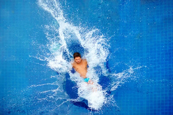 Man jumping in pool, huge splash, top view — Stock Photo, Image