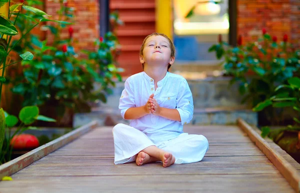 Lindo chico tratando de encontrar el equilibrio interior en la meditación — Foto de Stock