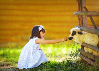cute girl, kid feeding lamb with grass, countryside clipart