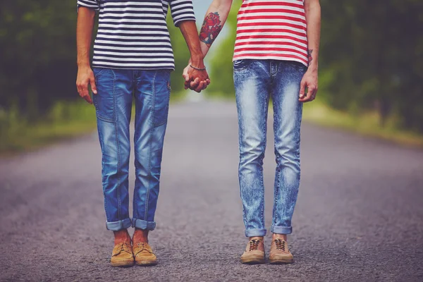 Jovem casal masculino de mãos dadas em pé em seu caminho juntos — Fotografia de Stock