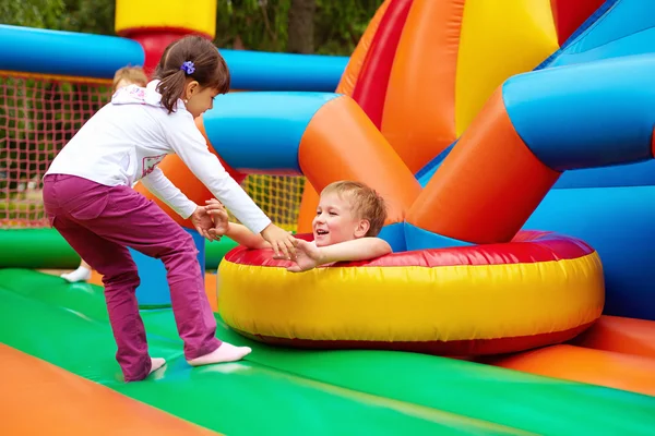 Счастливые дети веселятся на надувной игровой площадке — стоковое фото