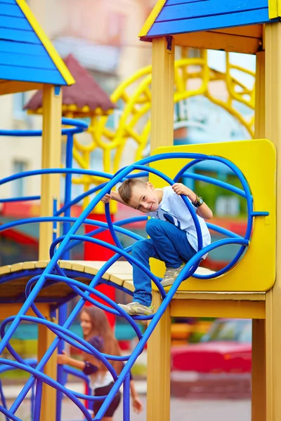 Счастливый ребенок, мальчик веселится на детской площадке в парке — стоковое фото