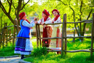 happy ukrainian women, dressed in traditional costumes, talking on the street