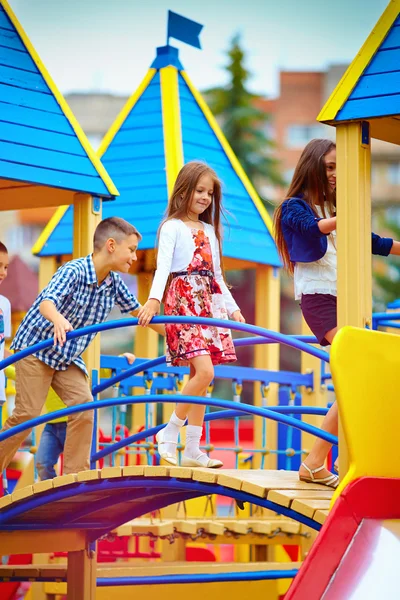 Группа счастливых детей, веселящихся на игрушечном замке, на детской площадке — стоковое фото