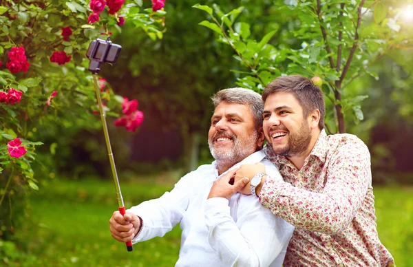 Like father like son. family makes selfie on smartphone — Stock fotografie