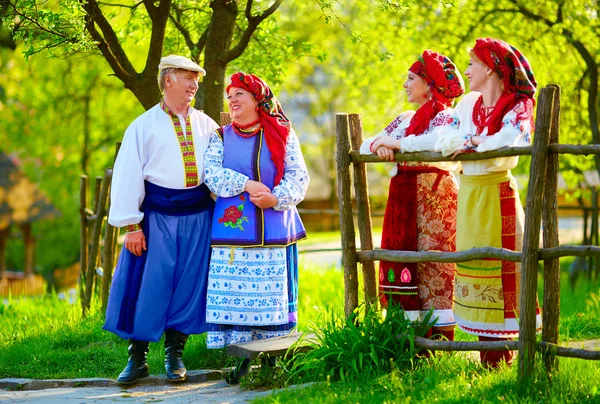 Heureuse famille ukrainienne, vêtue de costumes nationaux, parlant dans la rue — Photo