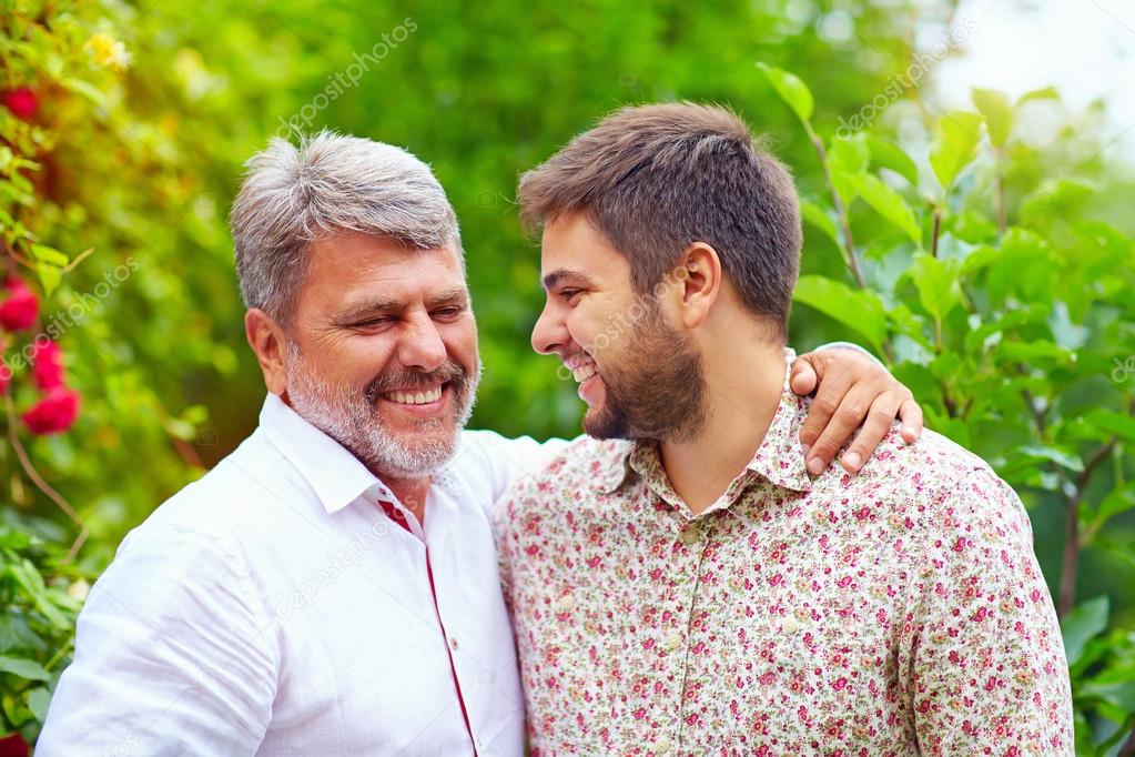 portrait of happy father and son talking outdoors. Like father like son