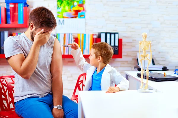 Family playing in doctor and patient, father scared of injection — Stock fotografie