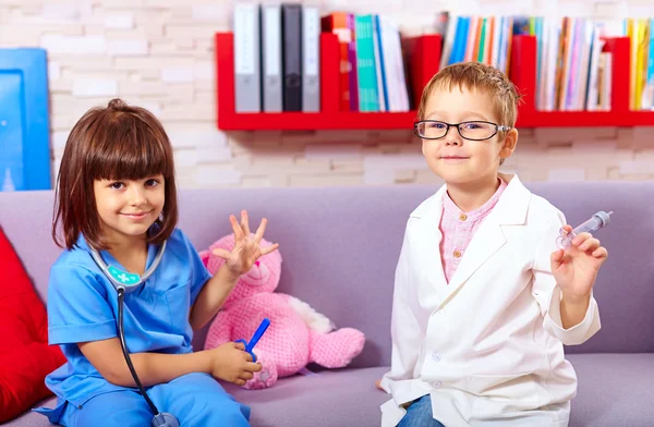 Cute kids playing in doctors with toy instruments — Zdjęcie stockowe