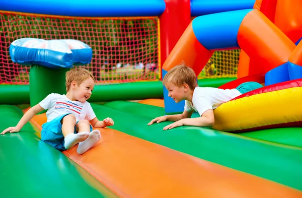 Gelukkige jonge geitjes plezier op opblaasbare attractie Speeltuin — Stockfoto