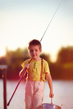 mutlu küçük çocuk sonra başarılı balıkçılık gölet üzerinde yürüme