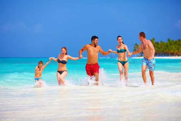 Grupp glada vänner kör tillsammans på tropical beach — Stockfoto