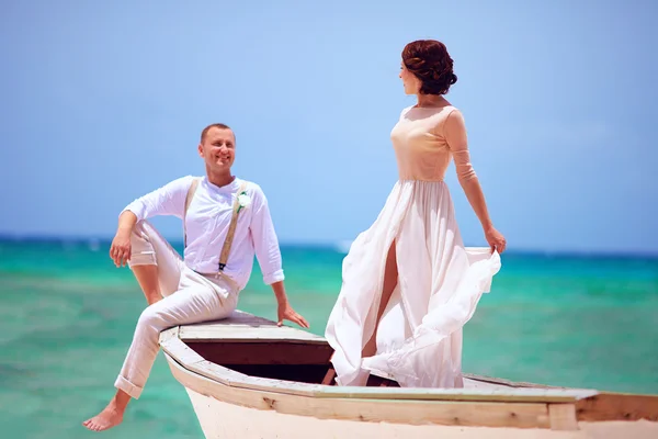 Beautiful bride and groom in boat swimming at caribbean sea — Stock Photo, Image