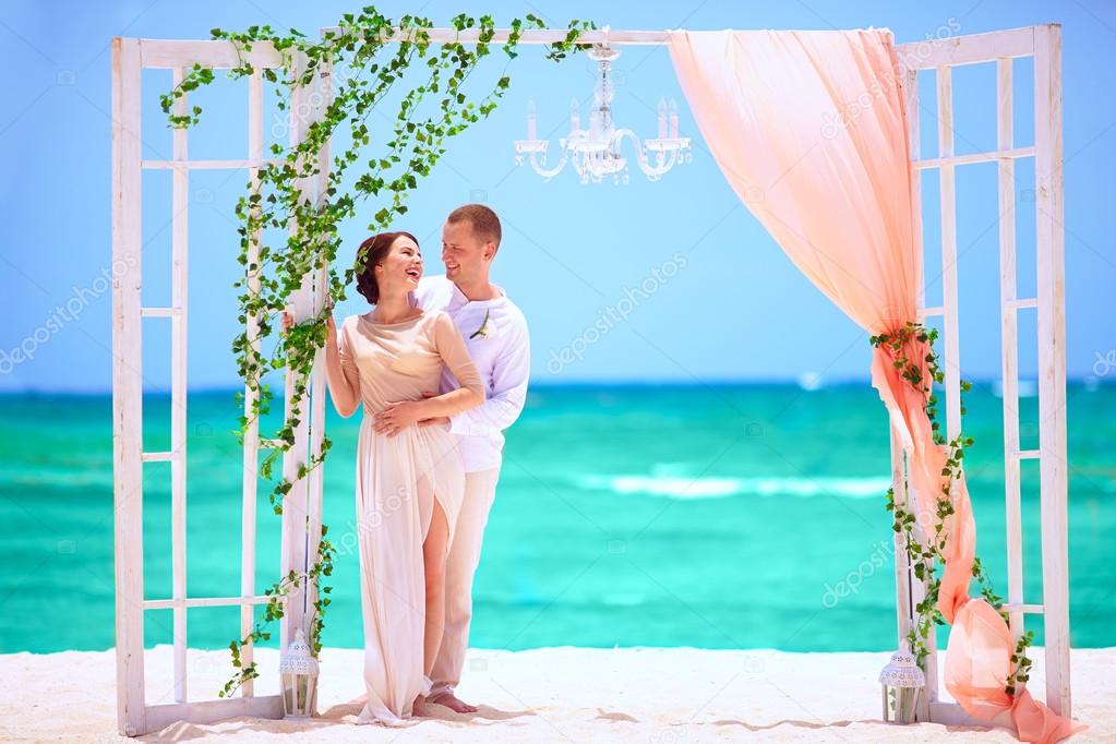 happy wedding couple on decorated tropical beach