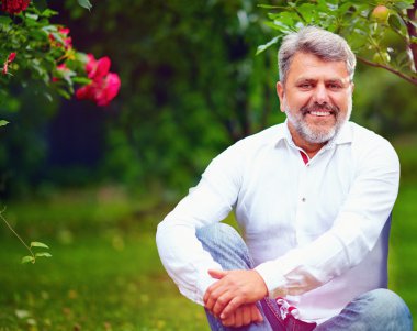Yaz bahçesinde yakışıklı olgun adam