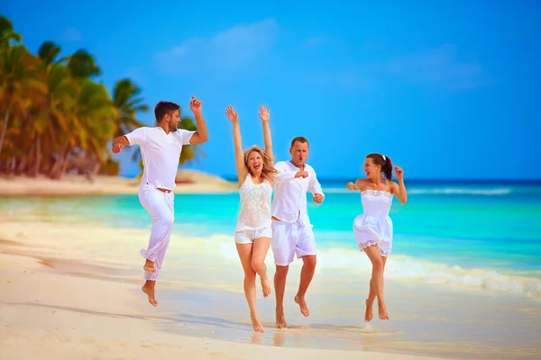Grupo de amigos felices corriendo en la playa tropical, vacaciones de verano —  Fotos de Stock
