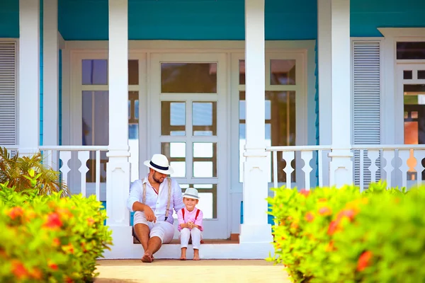 Lindo padre e hijo sentado en el porche, caribeño exterior — Foto de Stock