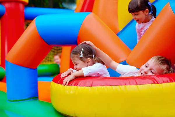 Excited kids having fun on inflatable attraction playground — Stock Photo, Image