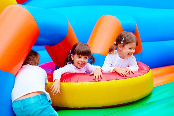 Excited kids having fun on inflatable attraction playground — Stock Photo, Image