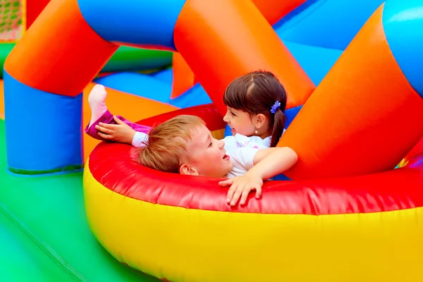 Возбужденные дети веселятся на надувной игровой площадке — стоковое фото