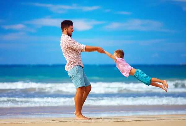 Счастливые взволнованные отец и сын, играющие на летнем пляже, наслаждаются жизнью — стоковое фото