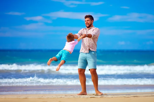 Felice padre e figlio eccitato che giocano sulla spiaggia estiva, godersi la vita — Foto Stock