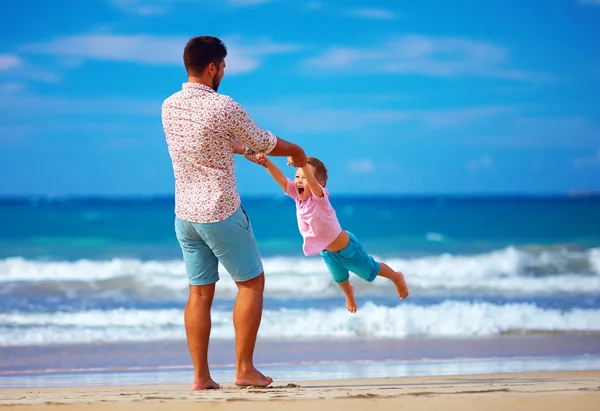 Happy excited father and son playing on summer beach, enjoy life Stock Picture