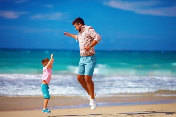 Feliz padre emocionado e hijo saltando en la playa de verano, disfrutar de la vida — Foto de Stock