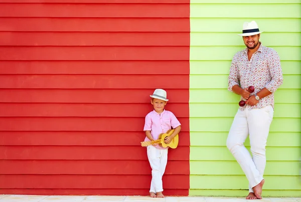 Mutlu baba ve oğul renkli duvarın yanında müzik aletleri ile — Stok fotoğraf