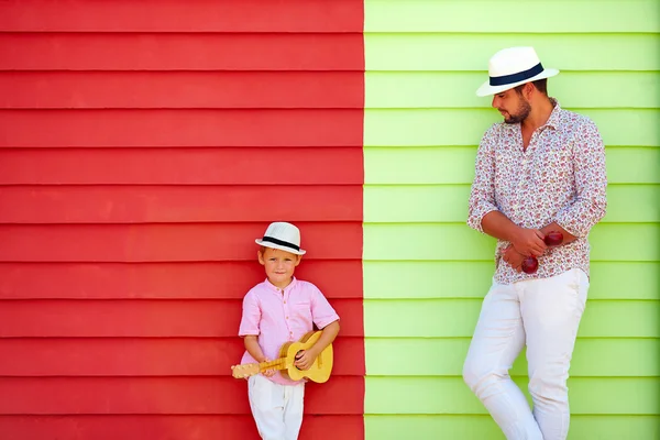 Szczęśliwy ojciec i syn z instrumentów muzycznych w pobliżu kolorowe ściany — Zdjęcie stockowe