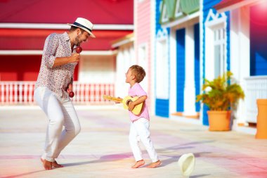 happy family playing music and dancing on caribbean street clipart