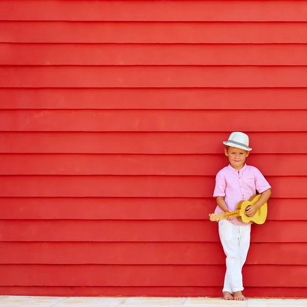 可爱的孩子，与夏威夷四弦琴演奏音乐的多彩墙附近 — 图库照片