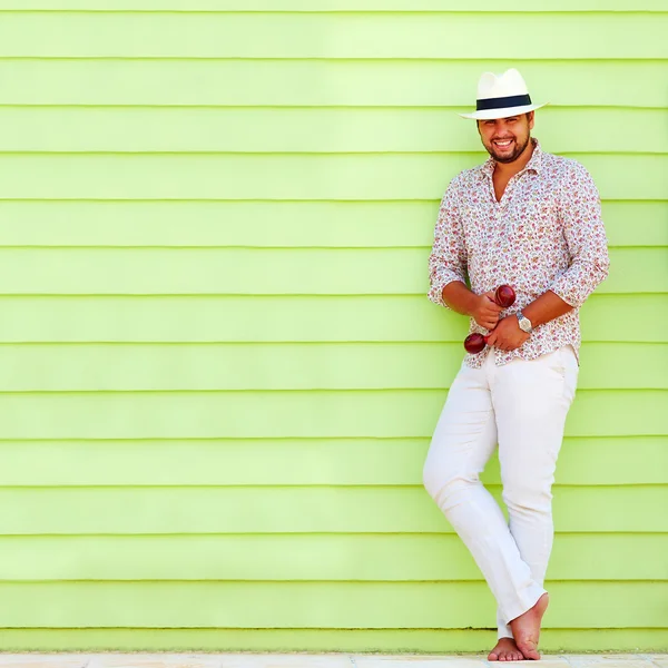 Hombre feliz con maraca tocando música cerca de la pared colorida —  Fotos de Stock