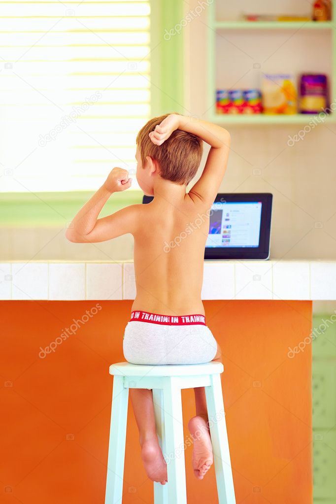 little boy stretching after sleep in the morning, while sitting in kitchen and waiting for breakfast