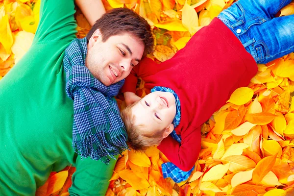 Feliz padre e hijo divirtiéndose en el parque de otoño —  Fotos de Stock