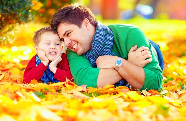 Feliz padre e hijo divirtiéndose en el parque de otoño — Foto de Stock